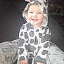 toddler, child, smiling, cow_costume, onesie, hood, ears, horns, happy, sitting, indoor, person, legs, clothing, cute, baby, cozy, fun, playful, joyful
