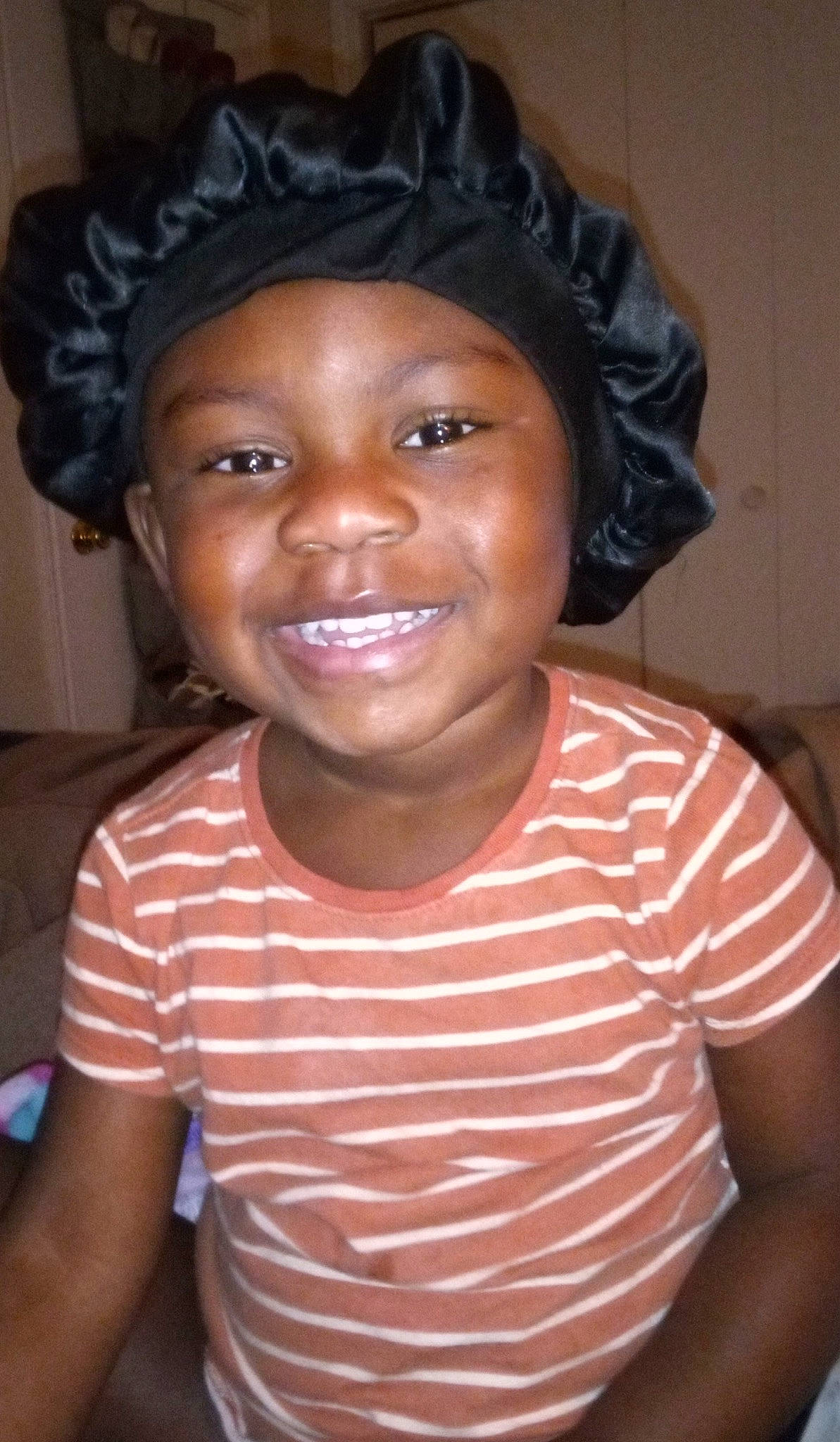 Jasiah is registered to the contest to win money with this photo: black_hair, cheek, child, chin, face, fashion_accessory, forehead, fun, happy, hat, headwear, human_body, joy, laugh, lip, nose, organ, person, skin, sleeve