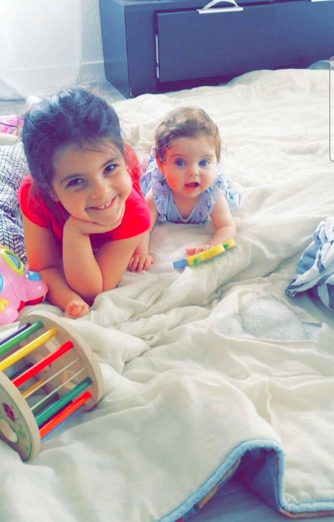 Jenna participe au concours pour gagner de l'argent avec cette photo : baby, baby_products, baby_toddler_clothing, bedding, child, comfort, electronic_device, face, fun, happy, head, joy, leisure, linens, person, play, product, room, skin, smile