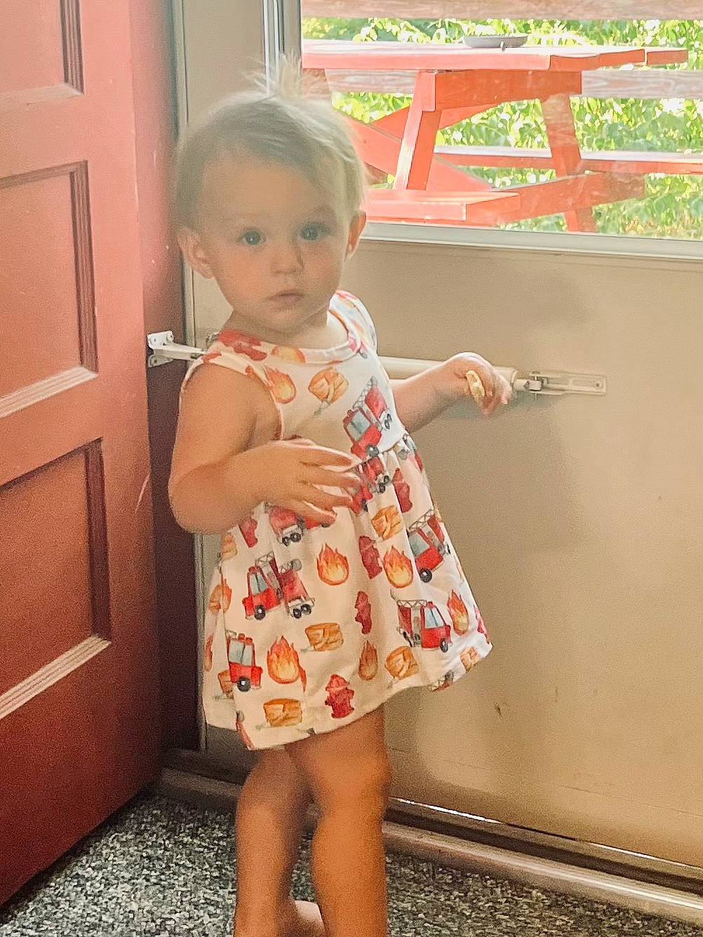 Tatum is registered to the contest to win money with this photo: baby_toddler_clothing, day_dress, door, dress, finger, flooring, gesture, hairstyle, happy, joint, neck, one_piece_garment, pattern, person, shoulder, skin, sleeve, standing, thigh, toddler