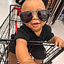 accessory, baby, belts, black_clothing, child, cute, face, fashion, hand, happy, head, indoor, mall, person, retail, shopping_cart, smiling, store, sunglasses, toddler
