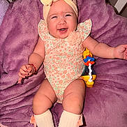Alessia is registered to the contest to win money with this photo: baby, bow, bracelet, child, cute, duck, floral_pattern, happy, headband, indoors, infant, lying_down, onesie, plush_blanket, purple_blanket, smiling, sock, toddler, toy, white_sock