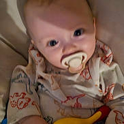 Harrison is registered to the contest to win money with this photo: baby, pacifier, toy, onesie, child, infant, hand, face, closeup, clothing, pattern, colorful, cute, indoors, young, person, soft, blurred, holding, play