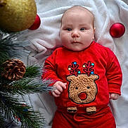 Lenny participe au concours pour gagner de l'argent avec cette photo : baby, infant, red_clothing, reindeer_design, christmas_tree, pinecone, christmas_ornament, blanket, holiday, festive, cute, face, child, indoors, floor, winter, seasonal, portrait, smiling, person