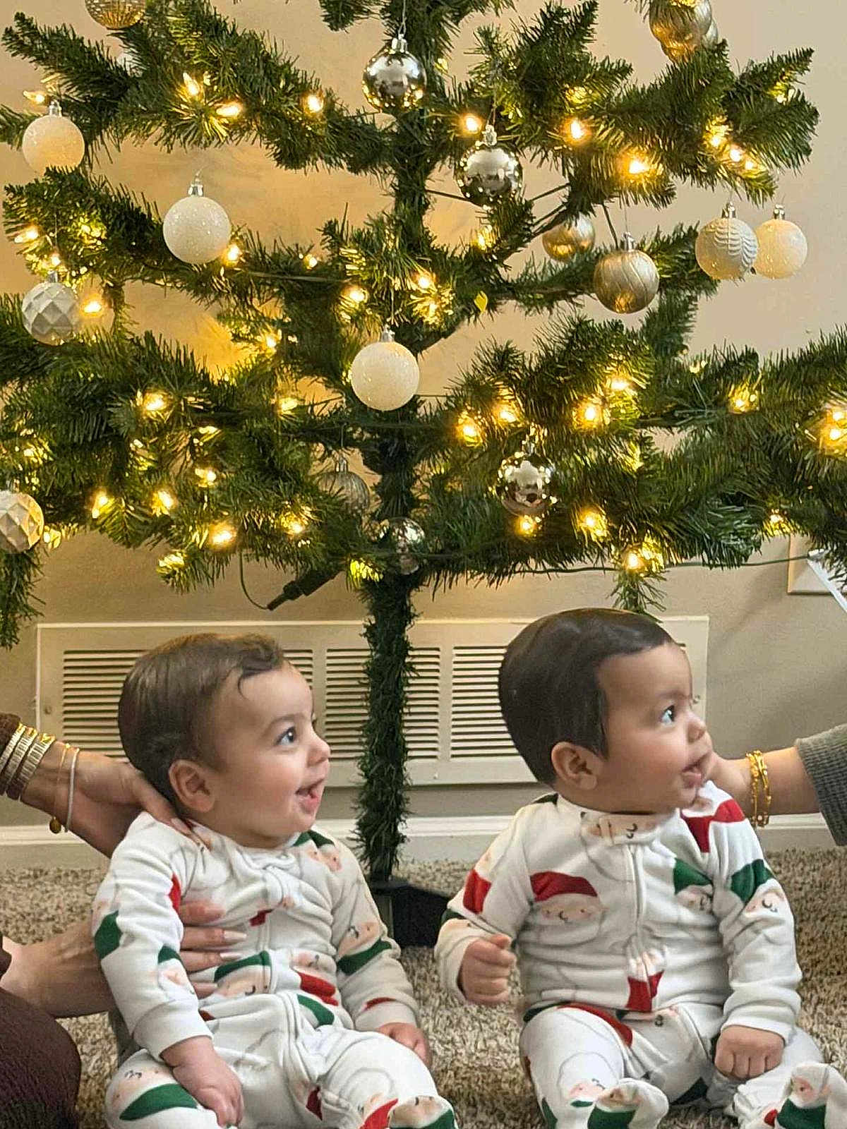Yahia joined the competition — help win amazing prizes! baby, babies, child, christmas_tree, christmas_lights, christmas_ornaments, pajamas, holiday, festive, indoor, carpet, smiling, happy, sitting, family, celebration, decorations, cute, toddler, infant