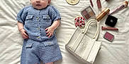 Olivia Jade joined the competition — help win amazing prizes! baby, infant, blue_knitted_outfit, white_socks, hair_clips, butterfly_clips, makeup_brush, lipstick, makeup_palette, handbag, white_blanket, wooden_plaque, cosy, cute, portrait, lying_down, soft_texture, fashion, child, four_months
