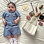 baby, infant, blue_knitted_outfit, white_socks, hair_clips, butterfly_clips, makeup_brush, lipstick, makeup_palette, handbag, white_blanket, wooden_plaque, cosy, cute, portrait, lying_down, soft_texture, fashion, child, four_months