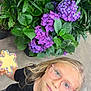 Penelope Rose is registered to the contest to win money with this photo: blond_hair, casual_clothing, child, colorful, concrete_floor, cookie, curious, flower, glasses, green_leaf, holding, indoor, looking_up, nature, person, plant, portrait, purple_flower, sprinkles, star_shape
