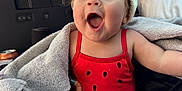 Arrow Saige joined the competition — help win amazing prizes! baby, child, car_seat, blanket, toy, hat, red_clothing, smiling, happy, indoors, seatbelt, cute, infant, expression, playful, colorful, fabric, face, person, warm