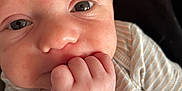 George joined the competition — help win amazing prizes! baby, close_up, face, hand, infant, onesie, striped_clothing, cute, skin, expression, newborn, person, child, portrait, young, small_hand, indoors, soft_light, human, cute_face