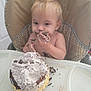 baby, blond_hair, cake, child, chocolate, cream, cute, dessert, eating, face, food, hands, happy, high_chair, indoor, messy, smile, sweet, table, toddler