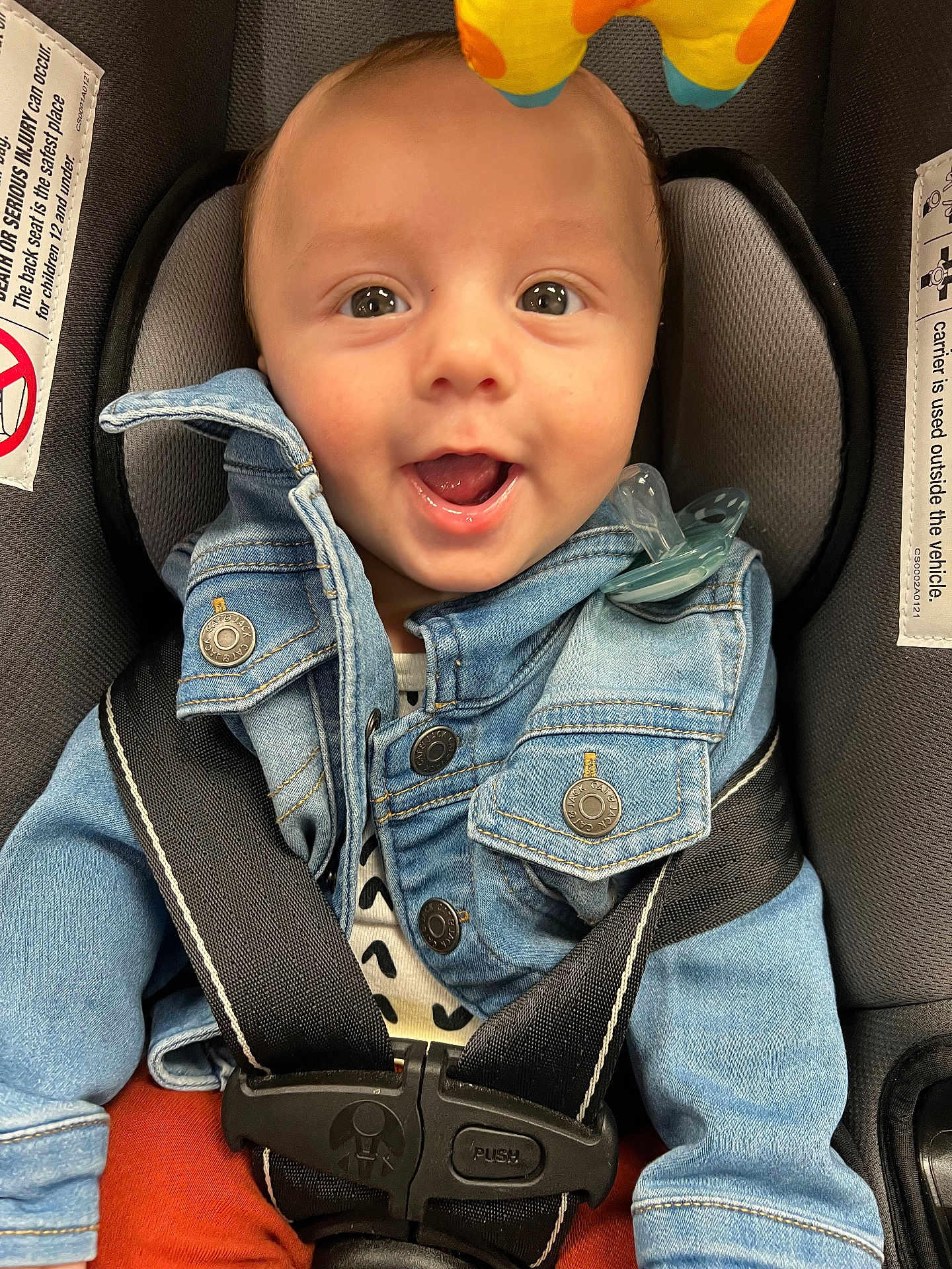 Nickolas joined the competition — help win amazing prizes! baby, denim_jacket, car_seat, pacifier, smiling, happy, child, seatbelt, toy, clothing, infant, cute, portrait, indoor, closeup, seat, safety, button, fabric, playful