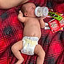 Nickolas is registered to the contest to win money with this photo: baby, infant, diaper, bottle, feeding, sleeping, blanket, plaid, snacks, food, leg, skin, hand, foot, relaxing, indoors, person, comfort, cute, lying_down