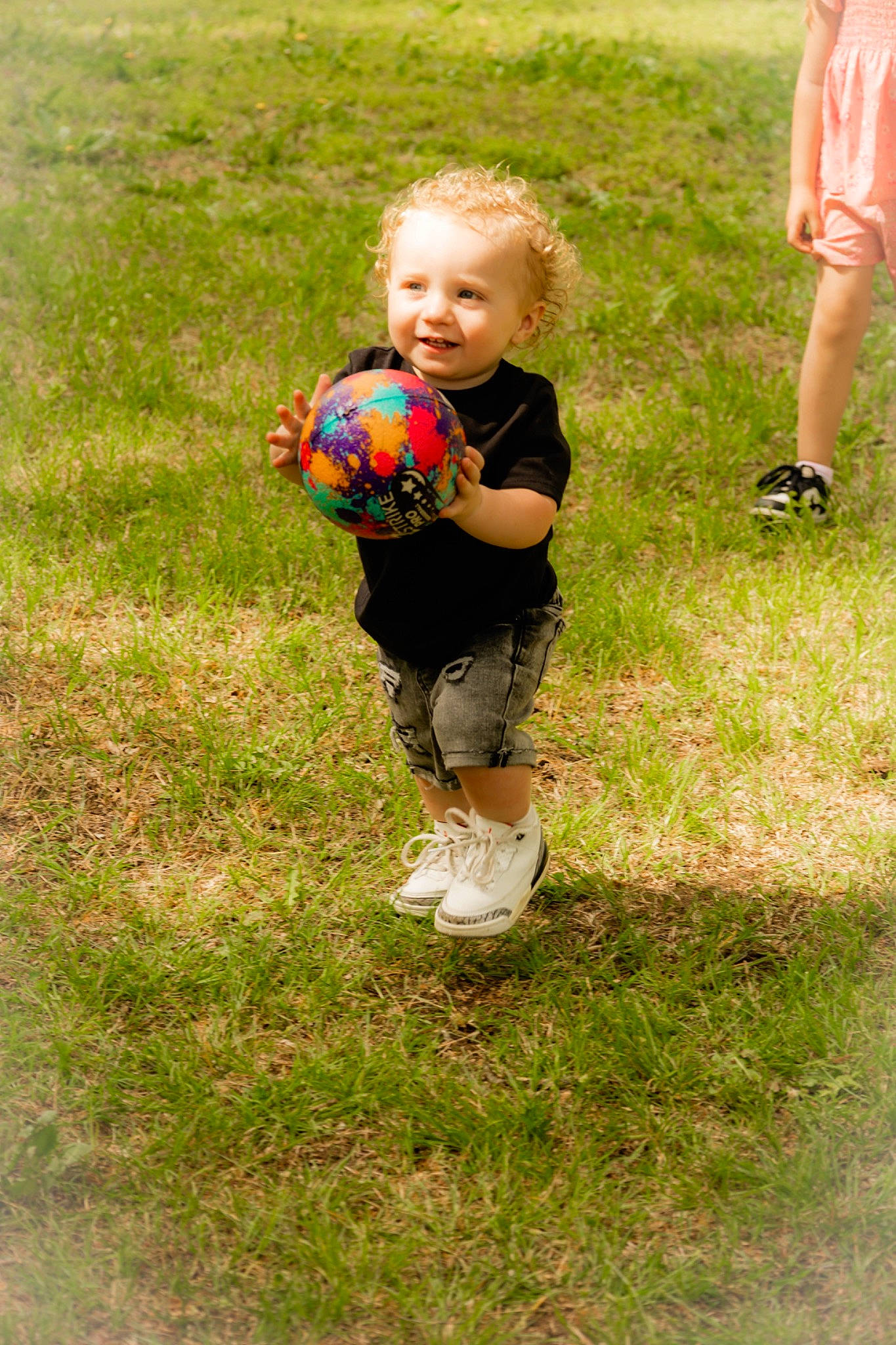 Emory is registered to the contest to win money with this photo: baby_toddler_clothing, ball, child, football, fun, grass, grassland, happy, joy, leisure, people_in_nature, person, play, recreation, shoe, shorts, smile, soccer_ball, soil, sports_equipment