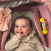 Aya a rejoint le concours — aidez-le/la à gagner de superbes lots ! baby, smiling, infant, baby_carrier, pink, knitwear, toy, hand, face, cute, child, portrait, happy, cozy, indoor, clothing, seatbelt, fabric, person, comfort