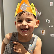 Ioachim a rejoint le concours — aidez-le/la à gagner de superbes lots ! child, smiling, paper_crown, handmade_craft, happy, portrait, close_up, indoor, fridge, magnets, stickers, tank_top, short_hair, teeth, eyes, skin, playful, celebration, bokeh, candid