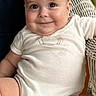 arm, baby, child, chubby_cheeks, closeup, cute, drool, expression, face, happy, head, indoors, infant, leg, onesie, person, seated, skin, smiling, wicker_chair