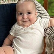 Will is registered to the contest to win money with this photo: baby, infant, smile, face, wicker_chair, white_onesie, cute, chubby_cheeks, portrait, child, sitting, indoors, relaxed, happy, young, person, skin, head, eyes, expression
