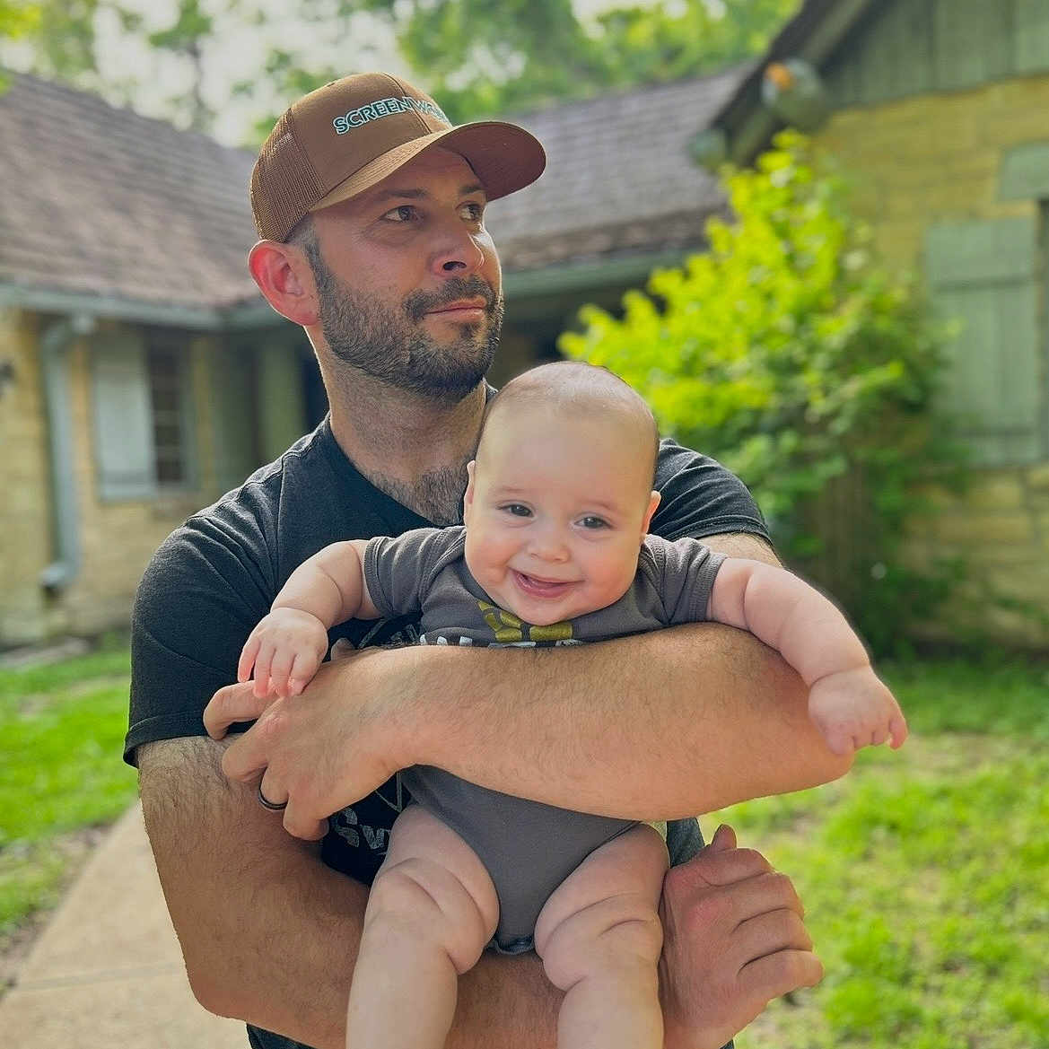 Will joined the competition — help win amazing prizes! man, baby, smile, holding, cap, beard, outdoor, house, greenery, grass, sidewalk, person, happy, child, casual_clothing, daylight, nature, family, portrait, toddler