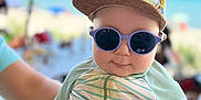 Jed participe au concours pour gagner de l'argent avec cette photo : baby, beach, cap, child, colorful, cute, fashion, outdoor, person, portrait, sea, smile, striped_clothing, summer, summer_fun, sunglasses, sunny, toddler, umbrella, vacation