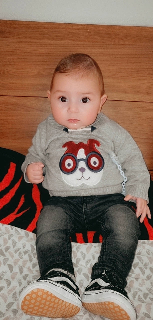 Riyad participe au concours pour gagner de l'argent avec cette photo : baby, baby_toddler_clothing, cheek, comfort, cool, eye, happy, head, human_body, leg, mouth, neck, pattern, person, shoulder, sitting, sleeve, t_shirt, textile, toddler