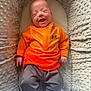 Marley is registered to the contest to win money with this photo: baby, smiling, infant, under_armour, orange_clothing, gray_pants, baby_nest, plush, soft_texture, happy, person, child, cute, newborn, lying_down, cozy, comfortable, apparel, footwear, portrait