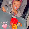 baby, high_chair, bottle, headband, pink_bow, toy, pacifier, child, indoor, table, face, hand, seat, cute, infant, expression, light, plastic, red, gray