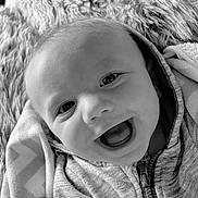 Michael is registered to the contest to win money with this photo: baby, infant, smile, happy, face, hoodie, blanket, closeup, portrait, child, baby_clothing, cozy, soft_texture, black_and_white, expression, cute, young_child, zipped_jacket, indoor, warm