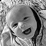 baby, infant, smile, happy, face, hoodie, blanket, closeup, portrait, child, baby_clothing, cozy, soft_texture, black_and_white, expression, cute, young_child, zipped_jacket, indoor, warm