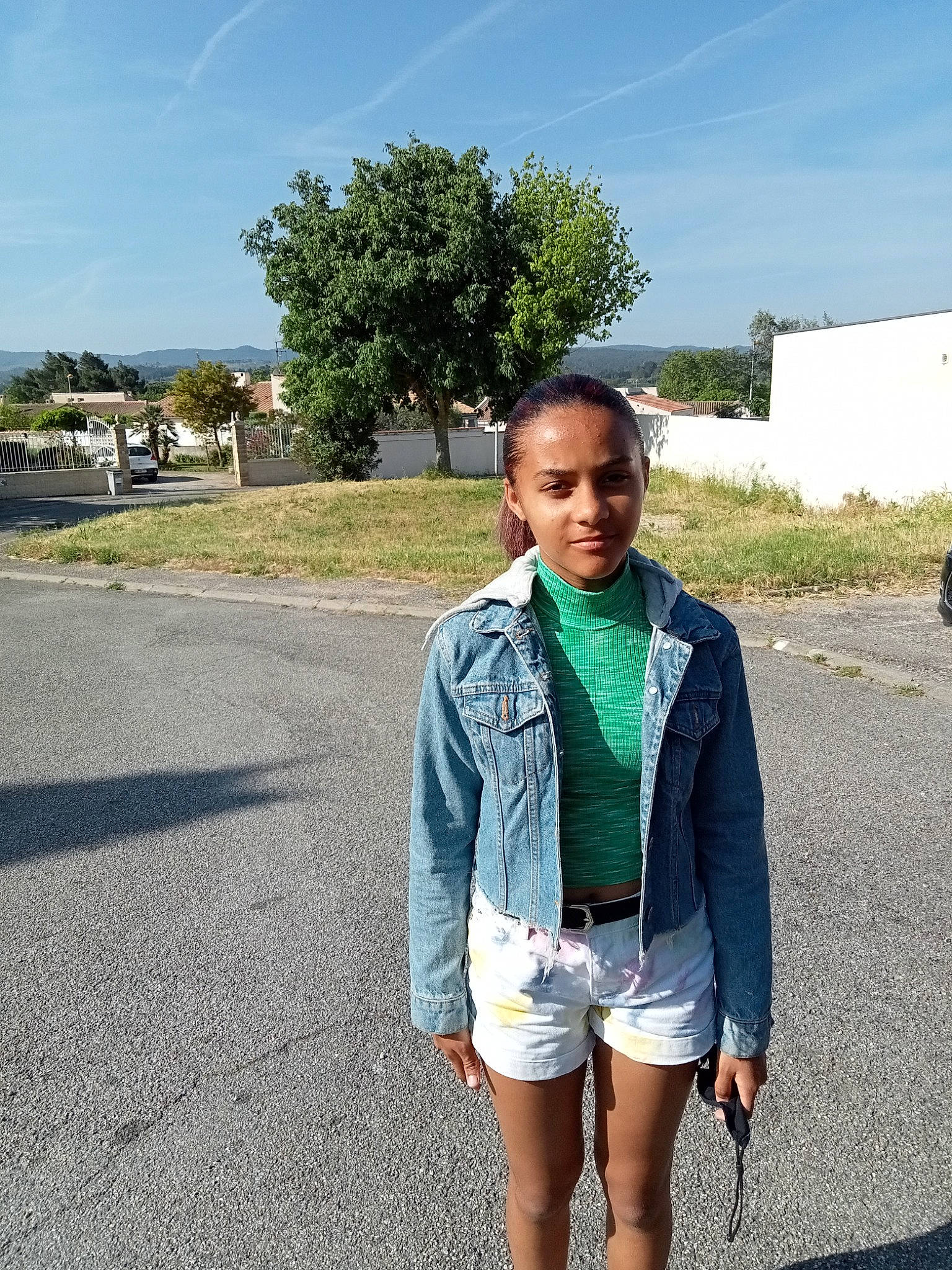 Marissa participe au concours pour gagner de l'argent avec cette photo : asphalt, bag, denim, electric_blue, grass, leisure, luggage_and_bags, person, plant, road, road_surface, shorts, sky, sleeve, street_fashion, t_shirt, thigh, travel, tree, trunk