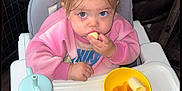 Paisley is registered to the contest to win money with this photo: banana, blueberries, breakfast, child, cute, eating, face, food, hair, high_chair, indoor, meal, nike_logo, peaches, person, pink_sweatshirt, sippy_cup, spoon, tableware, toddler