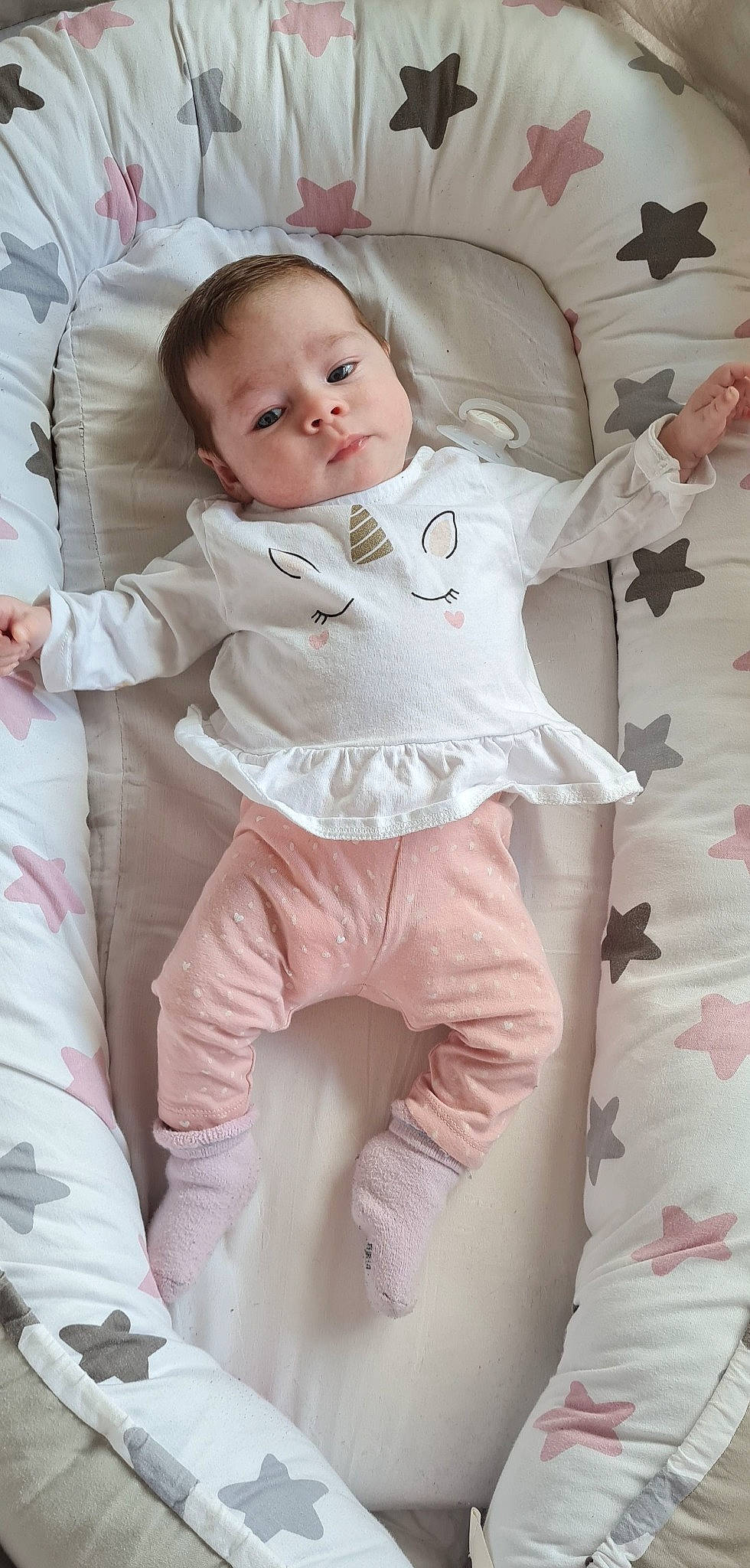 Thya participe au concours pour gagner de l'argent avec cette photo : arm, baby, baby_toddler_clothing, cheek, child, comfort, eye, face, gesture, happy, head, linens, person, pink, skin, sleeve, stomach, textile, thigh, toddler