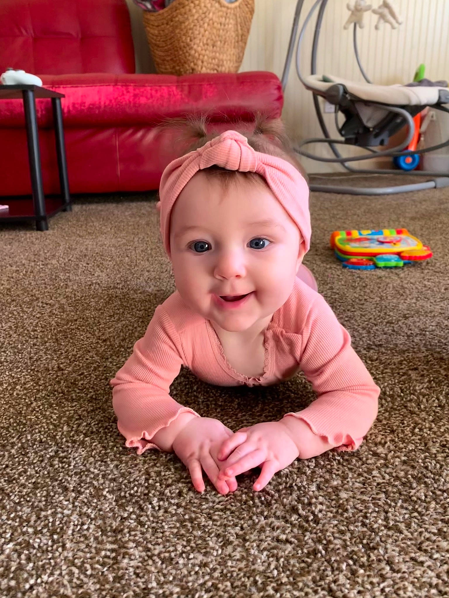 Althea is registered to the contest to win money with this photo: baby, baby_toddler_clothing, cheek, comfort, eye, face, floor, flooring, furniture, grass, happy, head, magenta, mammal, person, pink, red, skin, smile, toddler
