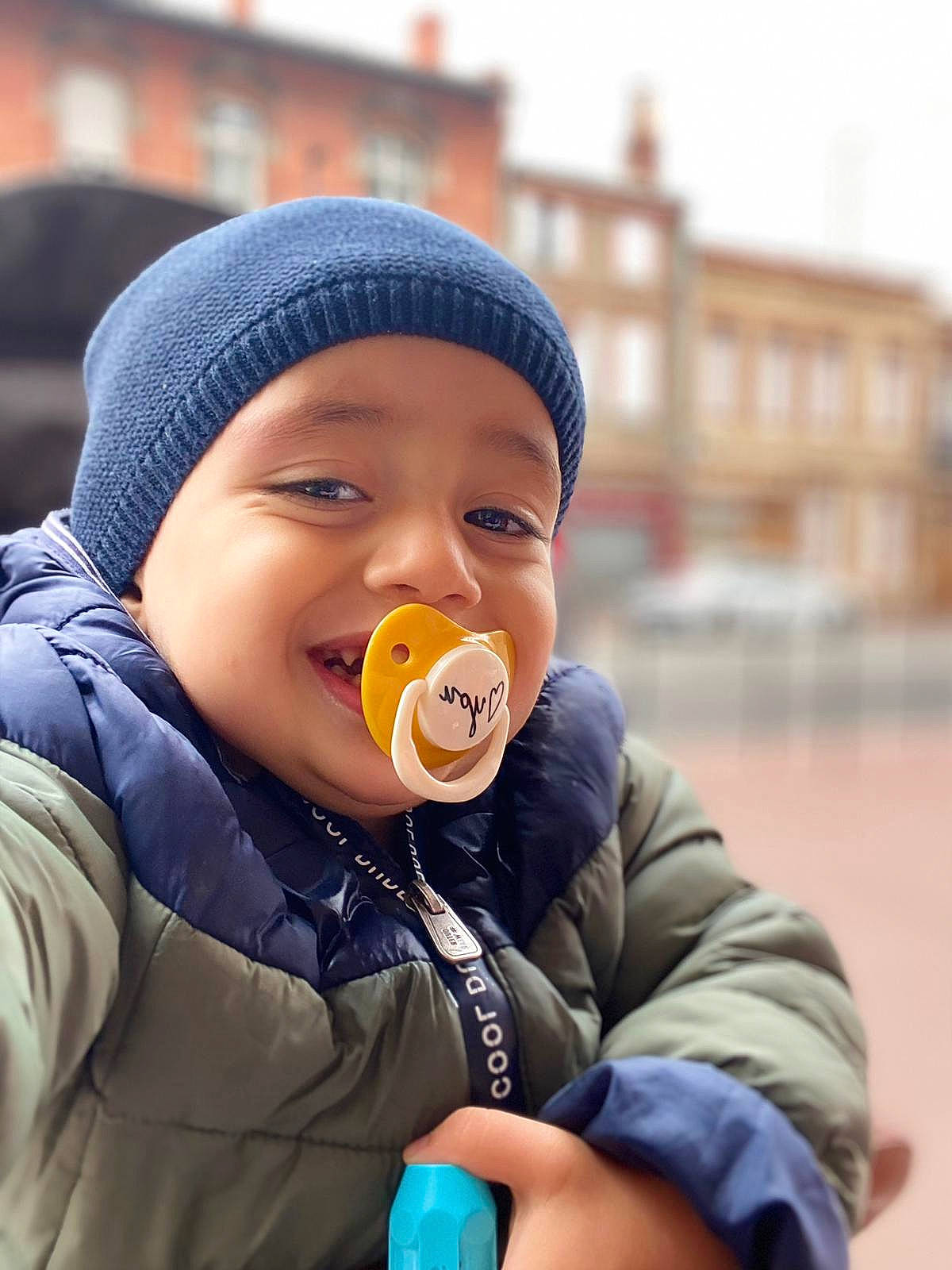 Zayn a rejoint le concours — aidez-le/la à gagner de superbes lots ! baby, baby_toddler_clothing, beanie, building, cap, cheek, child, eye, finger, fun, gesture, happy, headwear, joy, nose, person, sitting, sky, sleeve, toddler
