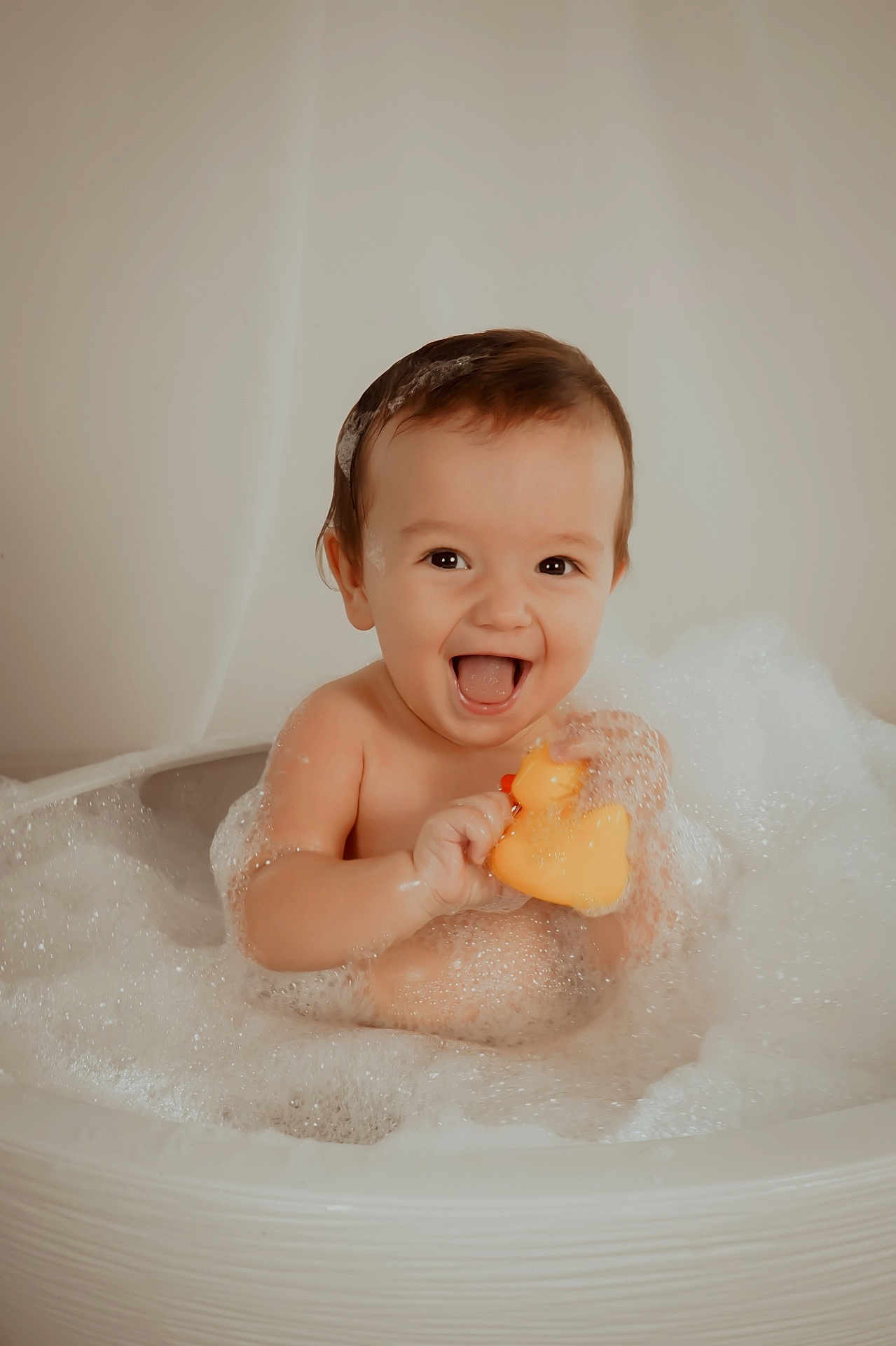 June participe au concours pour gagner de l'argent avec cette photo : baby, bath, bubbles, rubber_duck, foam, water, child, smiling, happy, playful, skin, head, face, toy, splash, tub, cute, infant, fun, cleaning