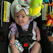 Aniyah joined the competition — help win amazing prizes! baby, car_seat, child, infant, toddler, bow, headband, toy, colorful, safety_harness, clothing, expression, indoor, cute, seat, child_safety, person, smile, face, closeup