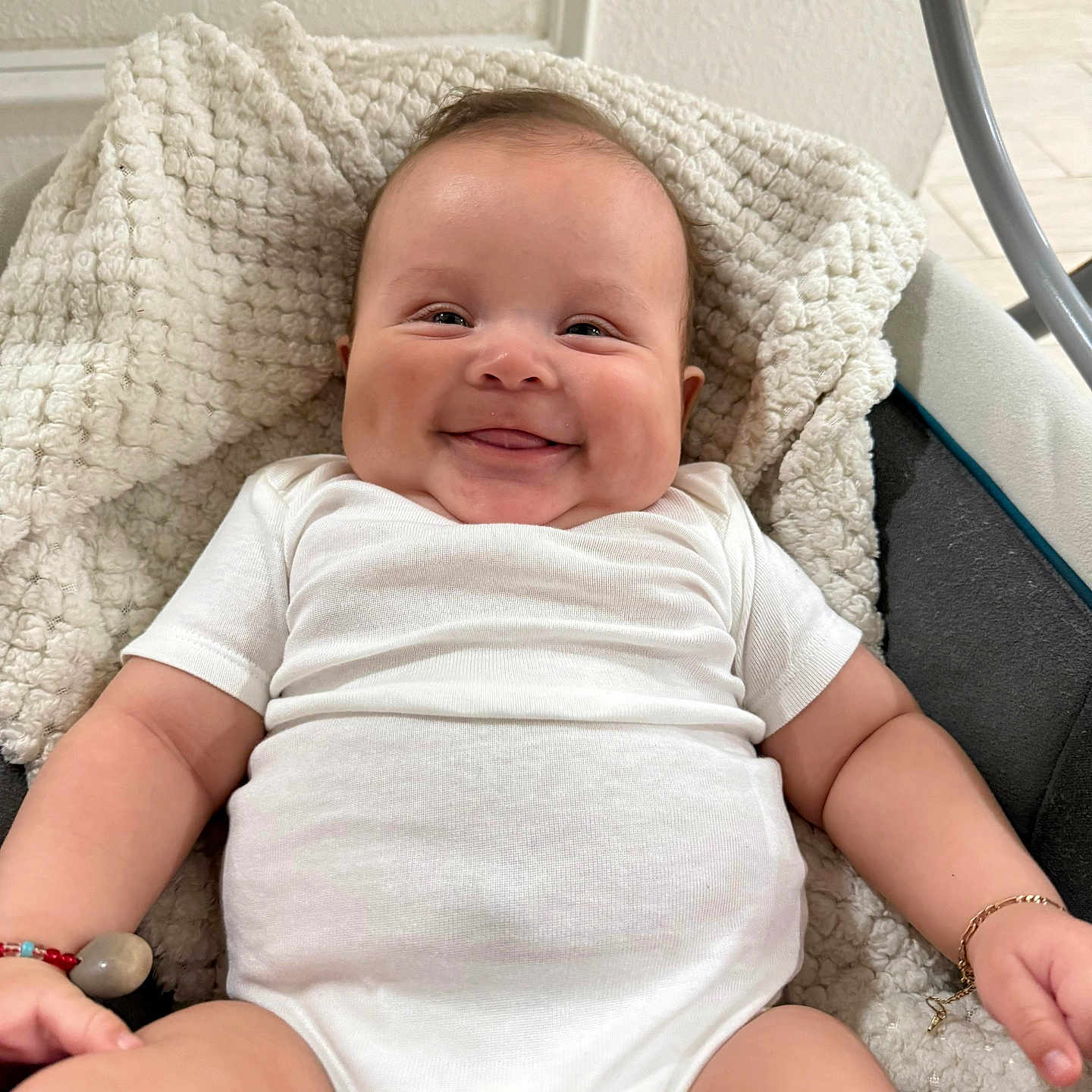 Liam Melgar joined the competition — help win amazing prizes! adorable, baby, blanket, bracelet, child, chubby_cheeks, closeup, cute, happy, indoor, infant, person, plush, portrait, relaxed, sitting, skin, smiling, soft_texture, white_onesie