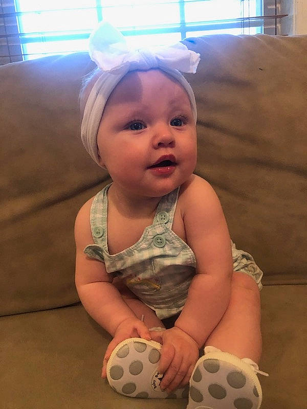 Elsie is registered to the contest to win money with this photo: baby, baby_toddler_clothing, cheek, child, comfort, face, flooring, fun, happy, head, headwear, human_body, human_leg, mammal, pattern, person, skin, smile, thigh, toddler