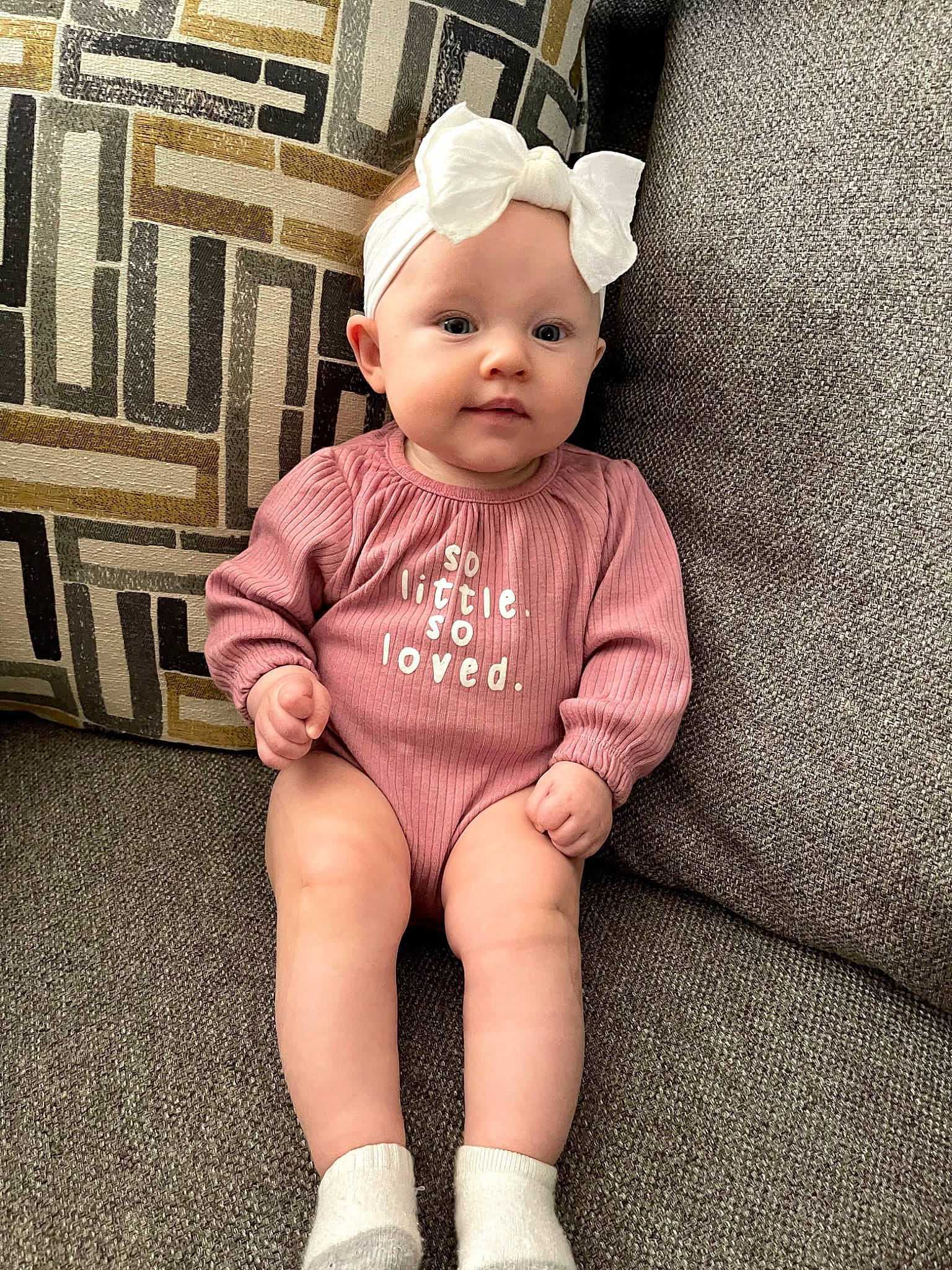 Elsie joined the competition — help win amazing prizes! baby, baby_toddler_clothing, cap, child, costume_hat, eye, fashion_accessory, happy, headwear, human_body, human_leg, knee, outerwear, pattern, person, sitting, sleeve, sock, t_shirt, textile