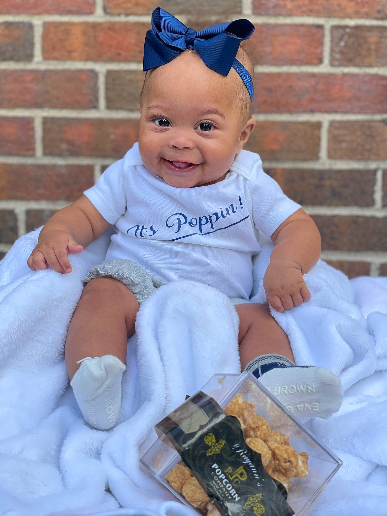 Emi is registered to the contest to win money with this photo: baby, baby_toddler_clothing, brick, cap, child, costume, costume_hat, electric_blue, event, happy, hat, head, joy, person, pink, product, purple, sitting, sleeve, smile