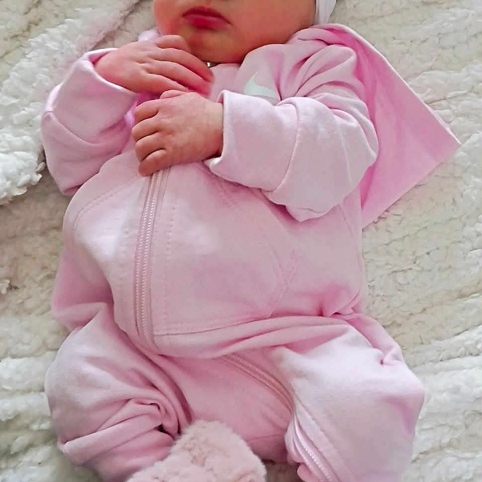 Naitilyn is registered to the contest to win money with this photo: baby, blanket, bow, child, closed_eyes, cozy, cute, fur_booties, hands, headband, indoors, infant, newborn, peaceful, pink_clothing, portrait, resting, sleeping, soft_texture, warm