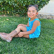 Ariana joined the competition — help win amazing prizes! child, girl, smiling, grass, greenery, outdoor, blue_clothing, boots, hair_buns, romper, nature, sunlight, happy, portrait, sitting, fence, hedge, casual, daytime, cute