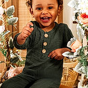 Nawfel a rejoint le concours — aidez-le/la à gagner de superbes lots ! child, toddler, smiling, green_outfit, indoor, flowers, wooden_bench, happy, cute, portrait, curly_hair, buttoned_shirt, playful, decor, plant_leaves, bright, warm_lighting, face, person, sitting