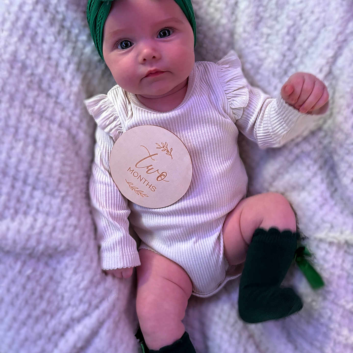 Ariella-May is registered to the contest to win money with this photo: baby, child, close_up, cute, face, green, headband, indoors, infant, knitted_blanket, legs, lying_down, newborn, portrait, skin, small_hands, socks, soft_texture, two_months, white_onesie