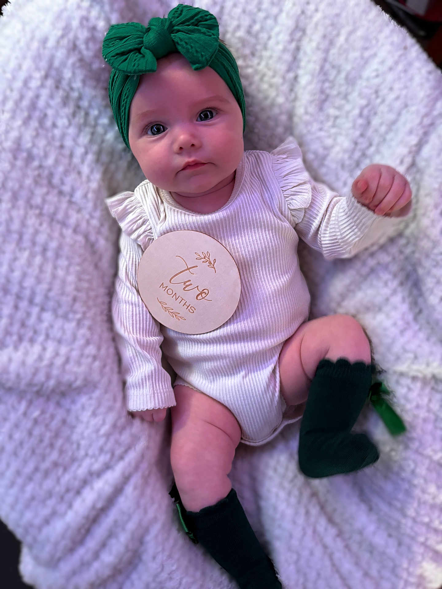 Ariella-May is registered to the contest to win money with this photo: baby, infant, two_months, headband, green, socks, white_onesie, knitted_blanket, soft_texture, lying_down, cute, portrait, child, newborn, indoors, close_up, face, skin, small_hands, legs