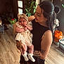 Ariella-May is registered to the contest to win money with this photo: baby, woman, mother, infant, tattoos, dress, headband, socks, indoor, flooring, plant, smile, holding, person, portrait, home, light, wooden_floor, happy, cute
