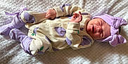 Ariella-May is registered to the contest to win money with this photo: baby, newborn, sleeping, onesie, purple, headband, bow, socks, blanket, soft_texture, clothing, infant, cute, resting, portrait, child, cozy, indoors, peaceful, closeup