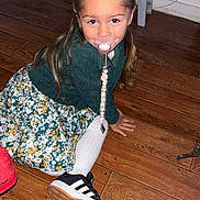 Mylla participe au concours pour gagner de l'argent avec cette photo : black_sneakers, bow, casual, child, cute, flooring, floral_dress, girl, green_clothing, hair, home, indoor, pacifier, person, playful, sitting, smiling, toy, white_tights, wooden_floor