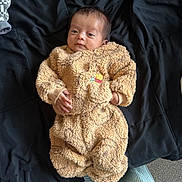 Matteo joined the competition — help win amazing prizes! baby, infant, teddy_bear_outfit, clothing, blanket, bed, face, person, sleepy, cute, cozy, hand, footwear, lying_down, indoor, soft_texture, warm, child, newborn, portrait