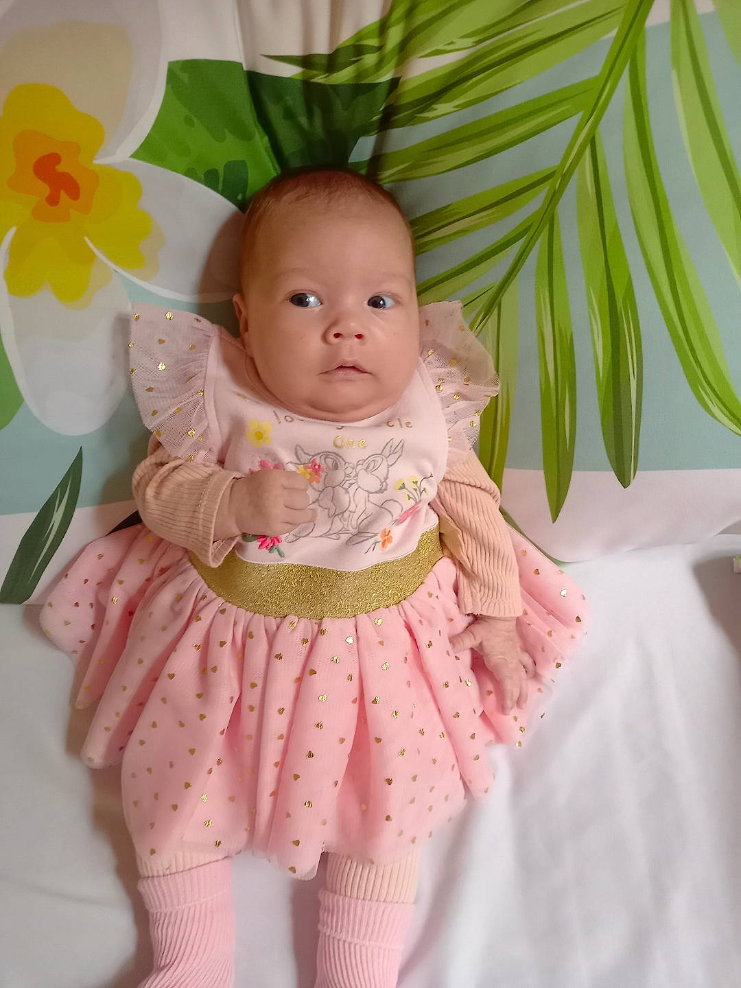 Inaya a rejoint le concours — aidez-le/la à gagner de superbes lots ! baby, baby_products, baby_toddler_clothing, cheek, child, eye, facial_expression, flower, happy, iris, magenta, pattern, peach, person, pink, skin, sleeve, textile, toddler, toy